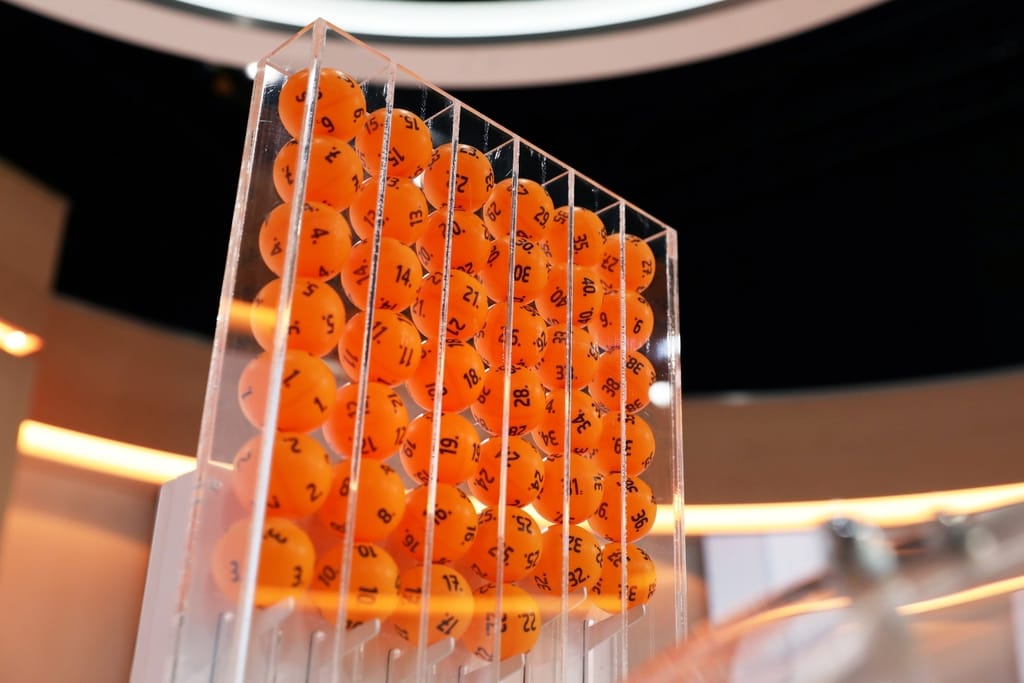 Oransseja numeroituja arvontapalloja läpinäkyvässä arvontalaitteessa.