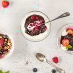 Mämmistä valmistettuja jälkiruokia kulhossa pöydällä. Vieressä marjoja.