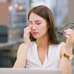 Nuori työntekijä stressaantuneena tietokoneella – tekoäly ja työpaineet kuormittavat työelämässä