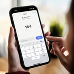Henkilö lähettämässä 15 euroa MobilePay-sovelluksella älypuhelimella.