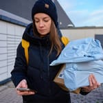 Nainen kantaa verkkokaupasta tilattuja paketteja